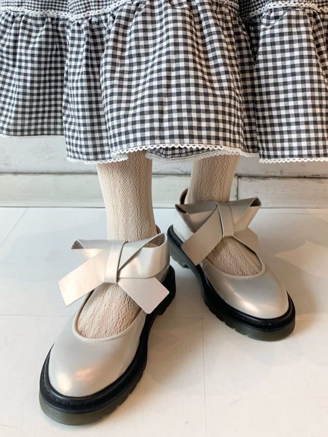 ホワイト系のパンプス、ブラック系のその他アウター、ホワイト系のシャツ/ブラウスを着用したレディースの冬コーディネートの6枚目の写真