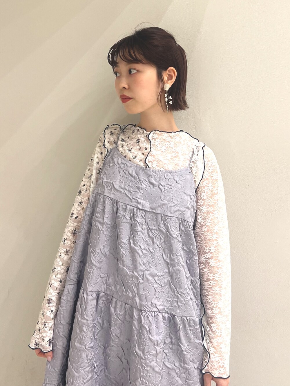 パープル系のワンピース、ホワイト系のTシャツ/カットソー、ホワイト系のサンダルを着用したレディースの夏コーディネートの7枚目の写真