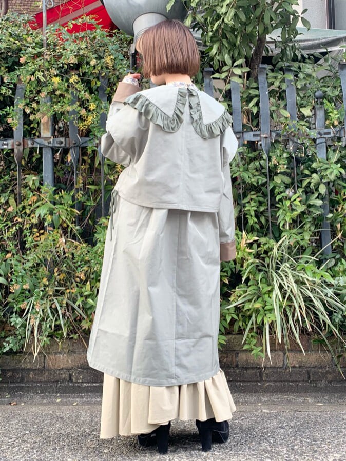 ブラック系のブーツ、ブルー系のシャツ/ブラウス、ベージュ系のトレンチコートを着用したレディースの冬コーディネートの2枚目の写真