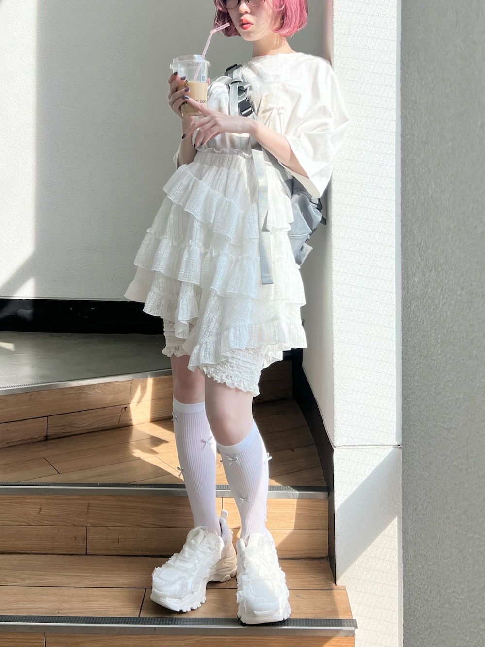 ホワイト系のTシャツ/カットソー、ホワイト系のスカート、ホワイト系のスニーカーを着用したレディースの春コーディネートの5枚目の写真