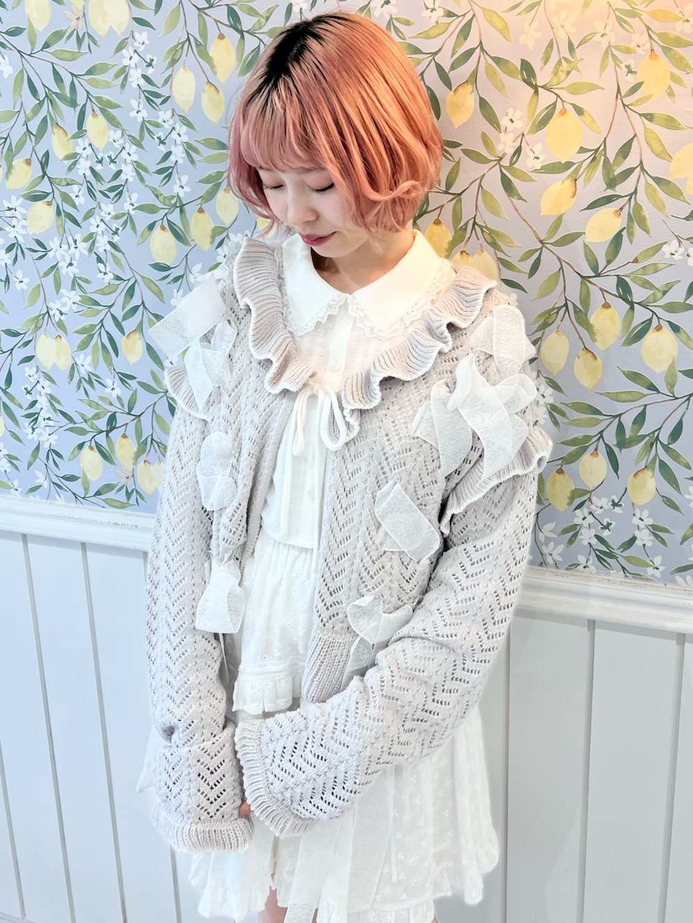 グレー系のカーディガン/ボレロ、ホワイト系のシャツ/ブラウス、ホワイト系のスカートを着用したレディースの冬コーディネートの6枚目の写真