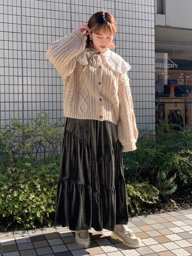 ホワイト系のニット/セーター、ホワイト系のカーディガン/ボレロ、ベージュ系のスカートを着用したレディースの冬コーディネートの2枚目の写真