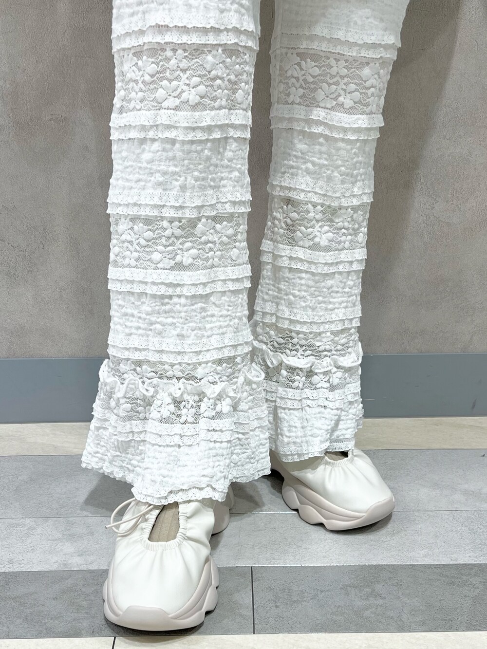 ホワイト系のデニムジャケット、ホワイト系のスラックス、ホワイト系のスニーカーを着用したレディースの秋コーディネートの10枚目の写真