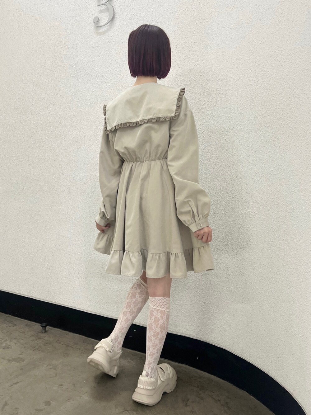 ベージュ系のワンピース、ホワイト系のスニーカーを着用したレディースの秋コーディネートの4枚目の写真