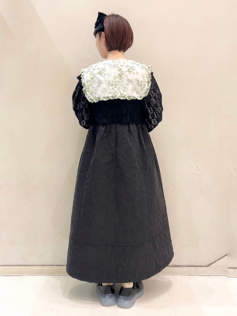 ブラック系のワンピース、ブラック系のカーディガン/ボレロ、ブラック系のスニーカーを着用したレディースの冬コーディネートの5枚目の写真