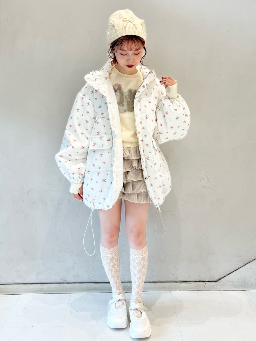 ピンク系のブルゾン、ベージュ系のスウェットパンツ、ホワイト系のニット/セーターを着用したレディースの冬コーディネートの7枚目の写真