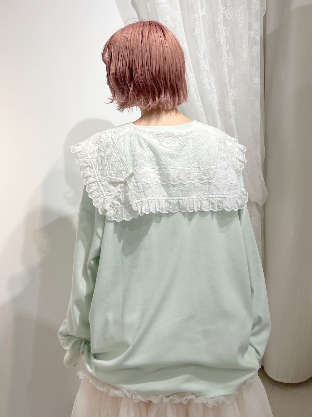 グリーン系のTシャツ/カットソー、ピンク系のスカート、ホワイト系のスニーカーを着用したレディースの夏コーディネートの7枚目の写真