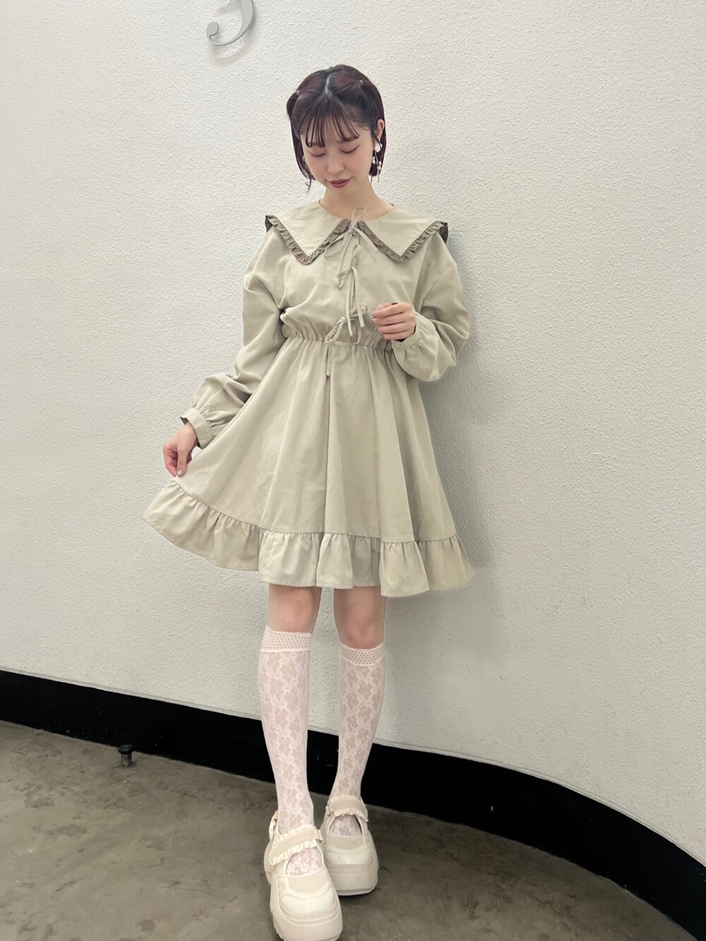 ベージュ系のワンピース、ホワイト系のスニーカーを着用したレディースの秋コーディネートの2枚目の写真