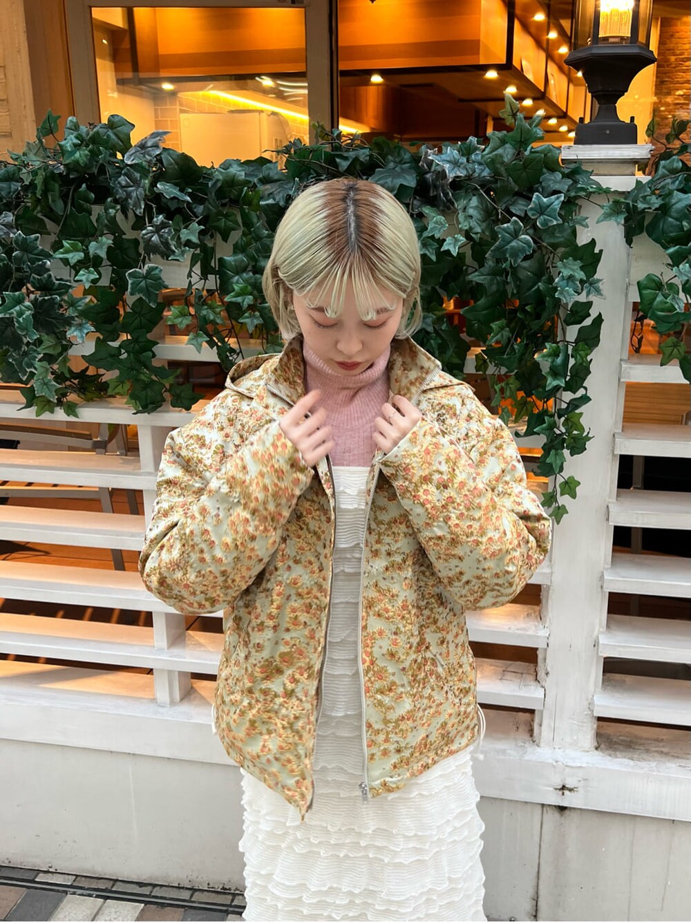 イエロー系のマウンテンパーカー、ホワイト系のブーツ、ホワイト系のワンピースを着用したレディースの秋コーディネートの7枚目の写真