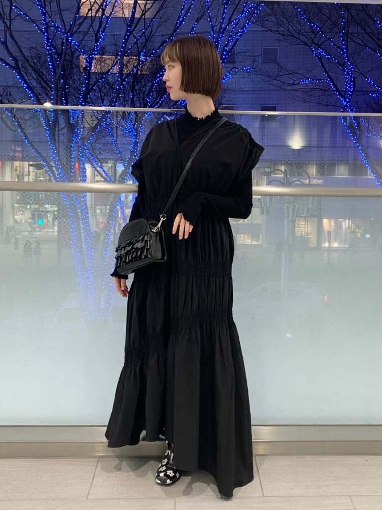 ブラック系のブーツ、ブラック系のニット/セーター、ブラック系のワンピースを着用したレディースの冬コーディネートの2枚目の写真