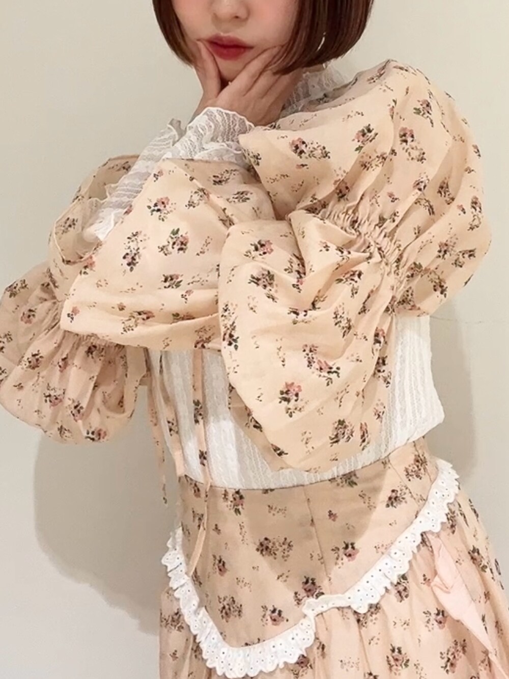 ピンク系のスカート、ピンク系のカーディガン/ボレロ、ホワイト系のパンプスを着用したレディースの春コーディネートの10枚目の写真