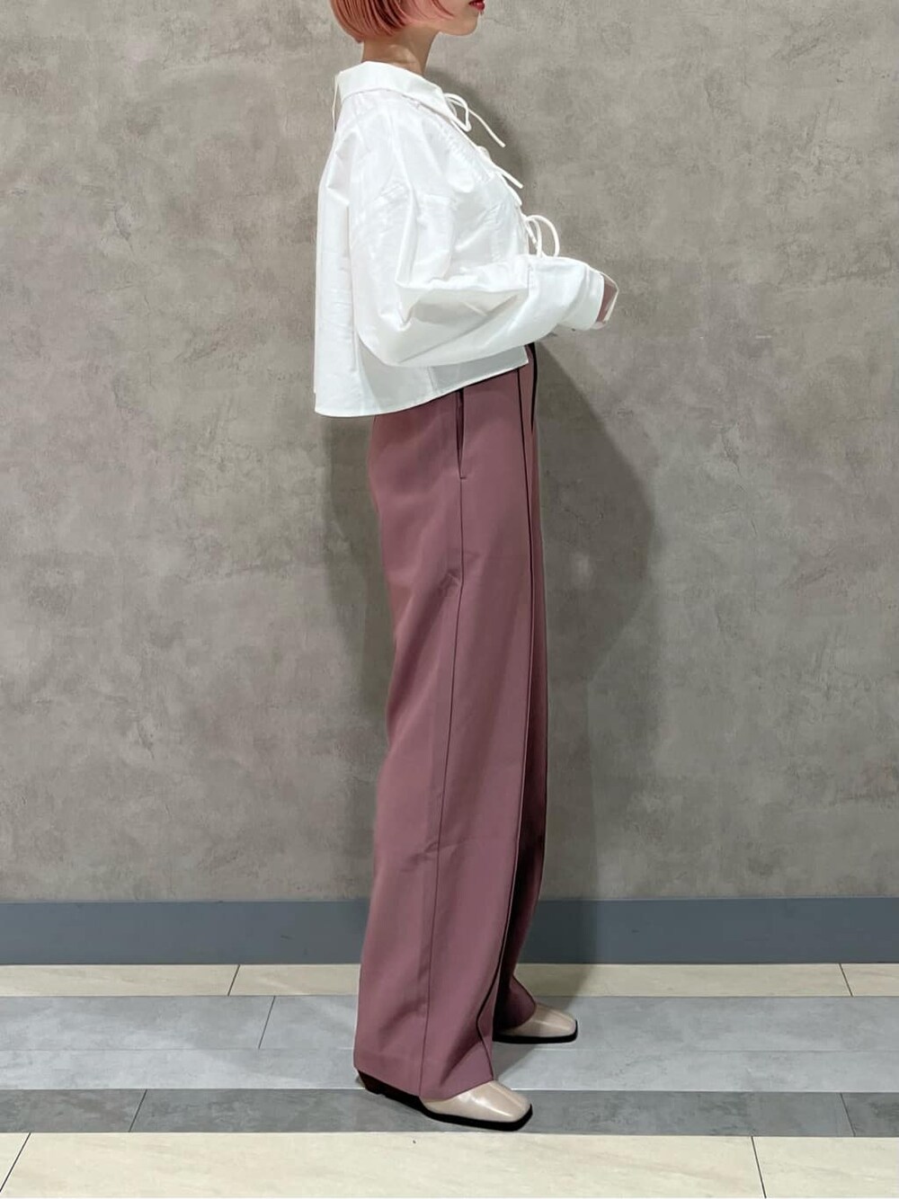 ホワイト系のシャツ/ブラウス、ピンク系のスラックス、ベージュ系のブーツを着用したレディースの秋コーディネートの3枚目の写真