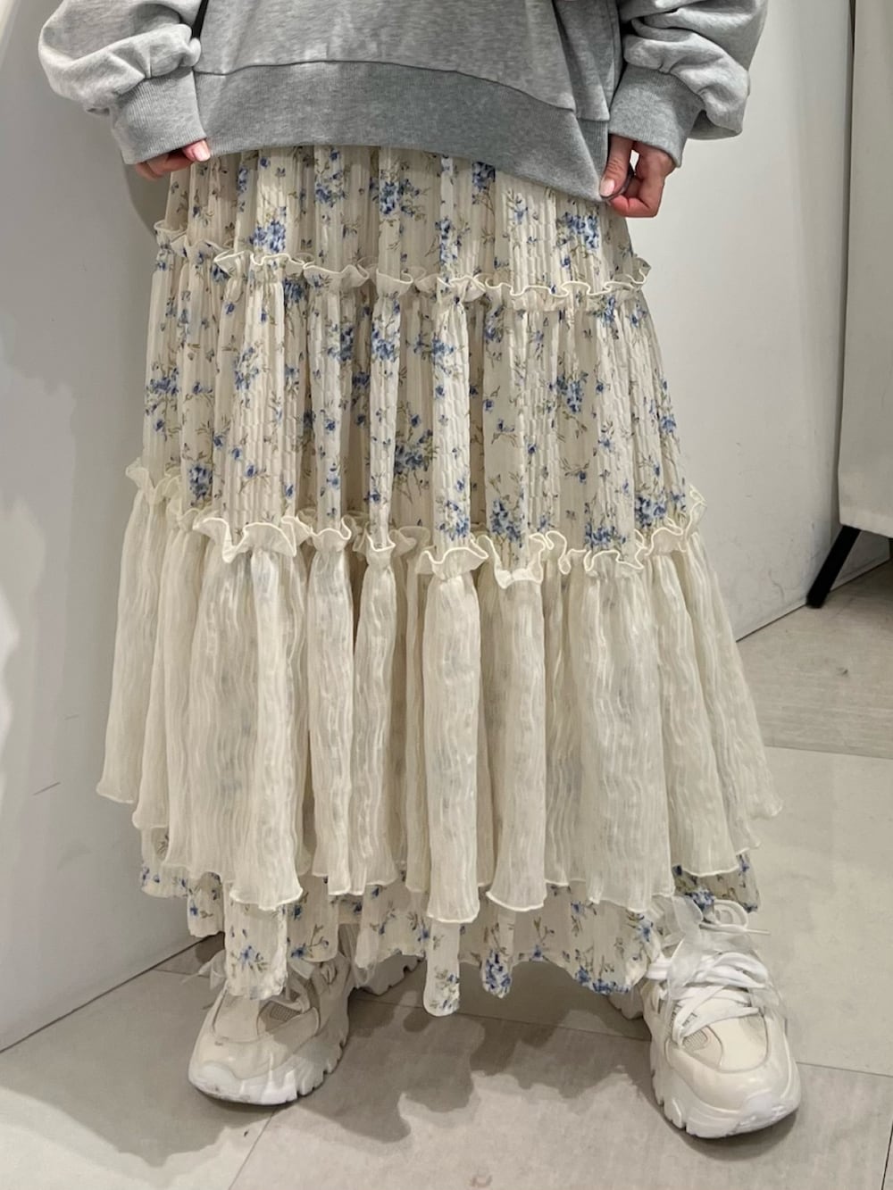 ホワイト系のショルダーバッグ、ホワイト系のスニーカー、ブルー系のスカートを着用したレディースの冬コーディネートの9枚目の写真