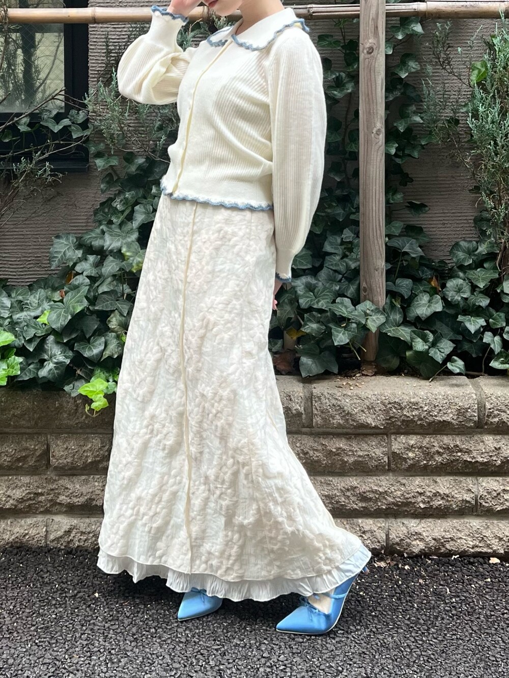 ホワイト系のニット/セーター、ホワイト系のワンピース、ブルー系のパンプスを着用したレディースの冬コーディネートの6枚目の写真