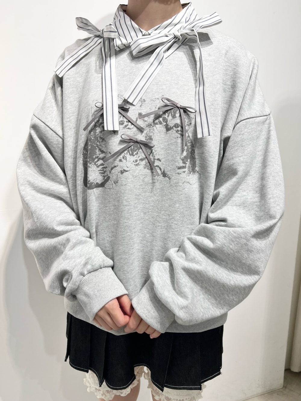 グレー系のスウェット、ブラック系のスカート、ブラック系のローファーを着用したレディースの秋コーディネートの8枚目の写真