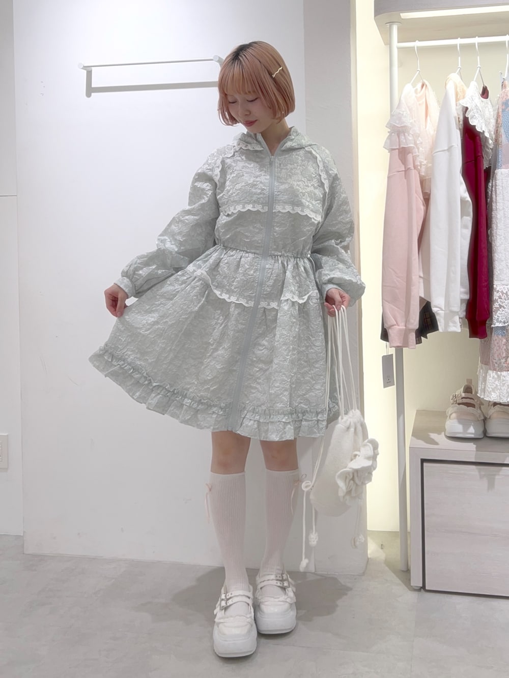 グリーン系のワンピース、ホワイト系のバックパック/リュック、ホワイト系のスニーカーを着用したレディースの秋コーディネートの2枚目の写真