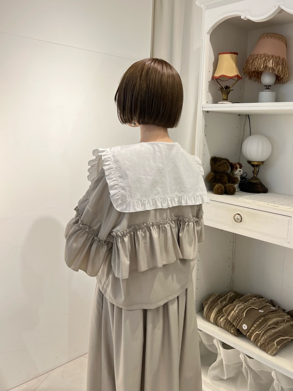 ホワイト系のシャツ/ブラウス、ベージュ系のスカート、ベージュ系のブーツを着用したレディースの冬コーディネートの8枚目の写真