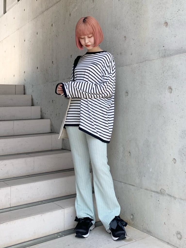 グリーン系のその他パンツ、ブラック系のスニーカー、ホワイト系のトートバッグを着用したレディースの春コーディネートの3枚目の写真