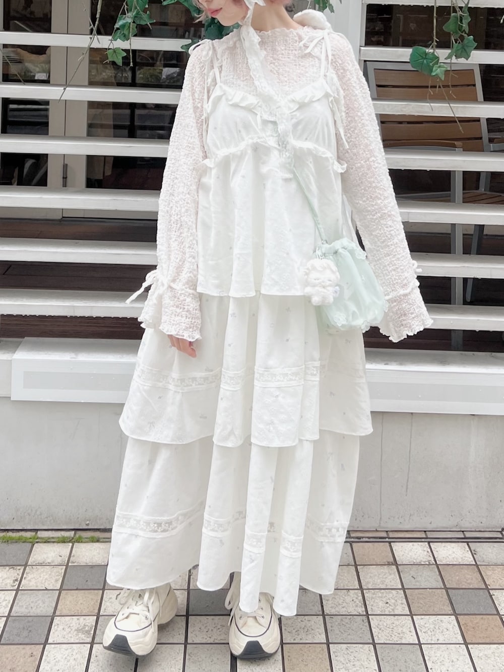 ホワイト系のTシャツ/カットソー、グリーン系のハンドバッグ、ホワイト系のワンピースを着用したレディースの冬コーディネートの4枚目の写真