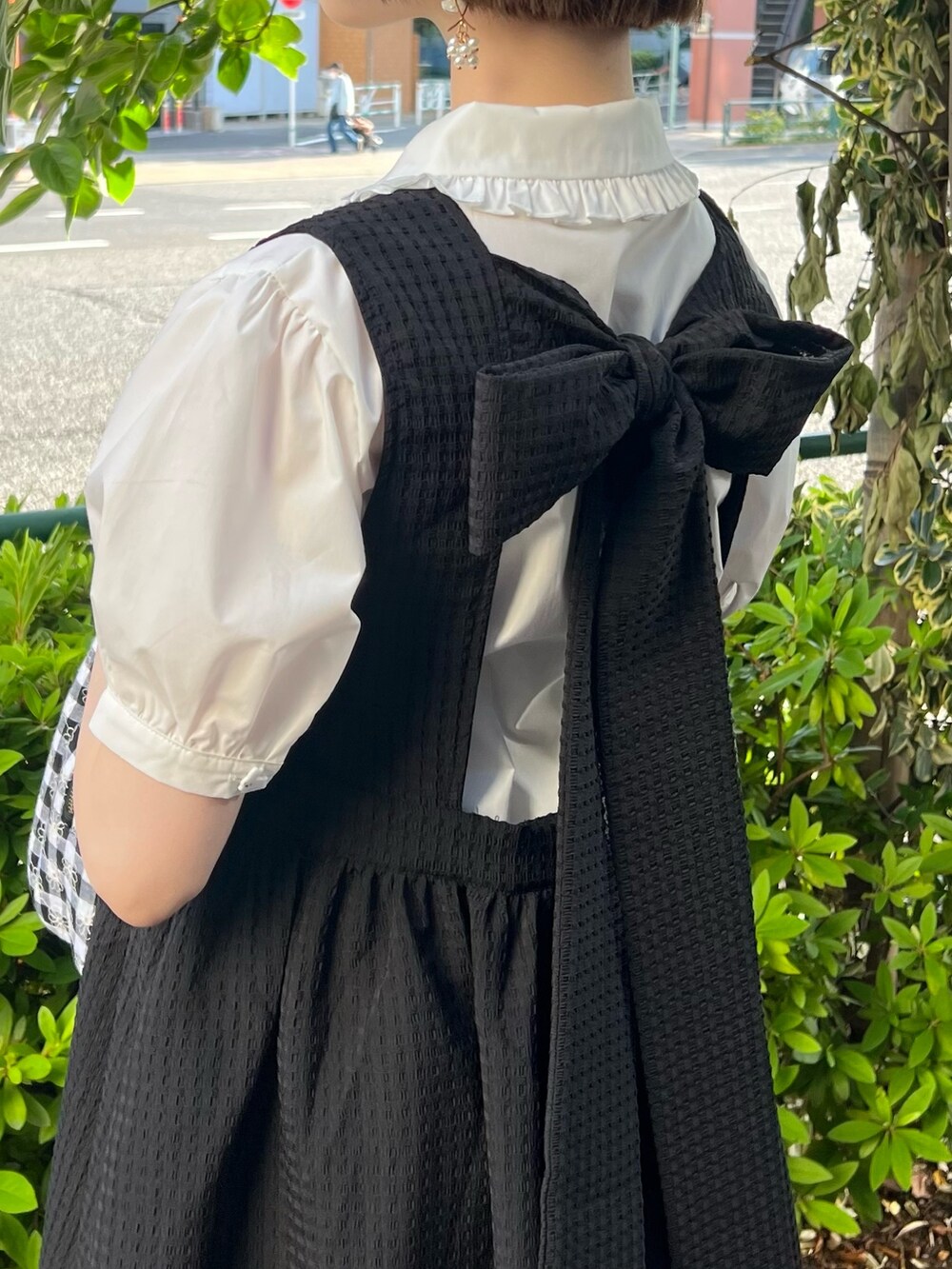 ブラック系のハンドバッグ、ブラック系のワンピース、ブラック系のサンダルを着用したレディースの春コーディネートの5枚目の写真