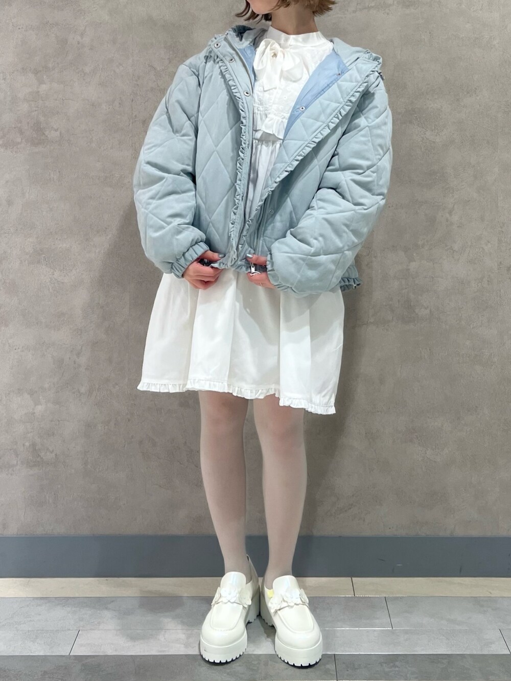 ブルー系のその他アウター、ホワイト系のワンピース、ホワイト系のローファーを着用したレディースの冬コーディネートの2枚目の写真