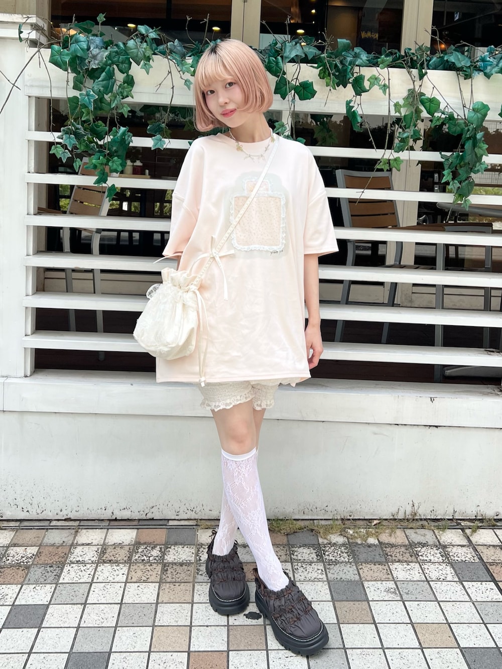 ピンク系のTシャツ/カットソー、ブラウン系のサンダル、ホワイト系のショルダーバッグを着用したレディースの夏コーディネートの2枚目の写真