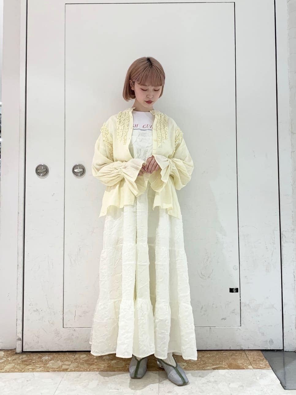 ホワイト系のワンピース、ブルー系のパンプス、イエロー系のシャツ/ブラウスを着用したレディースの夏コーディネートの2枚目の写真