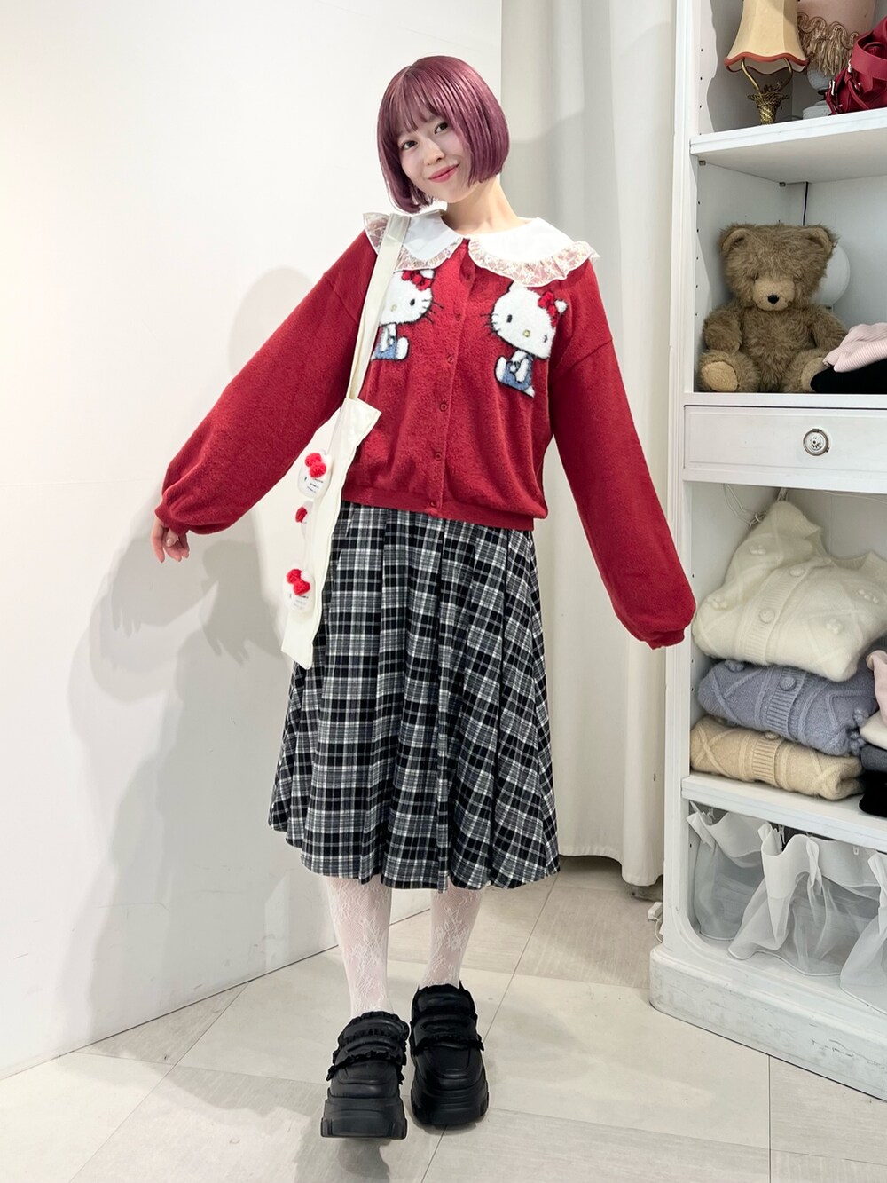 レッド系のカーディガン/ボレロ、ゴールド系のシャツ/ブラウス、ブラック系のスカートを着用したレディースの秋コーディネートの2枚目の写真