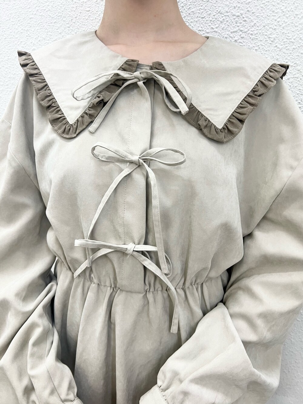 ベージュ系のワンピース、ホワイト系のスニーカーを着用したレディースの秋コーディネートの6枚目の写真