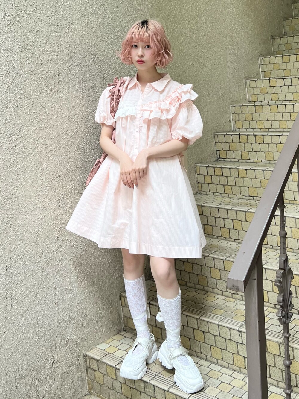 ピンク系のワンピース、ピンク系のトートバッグ、ホワイト系のスニーカーを着用したレディースの春コーディネートの4枚目の写真