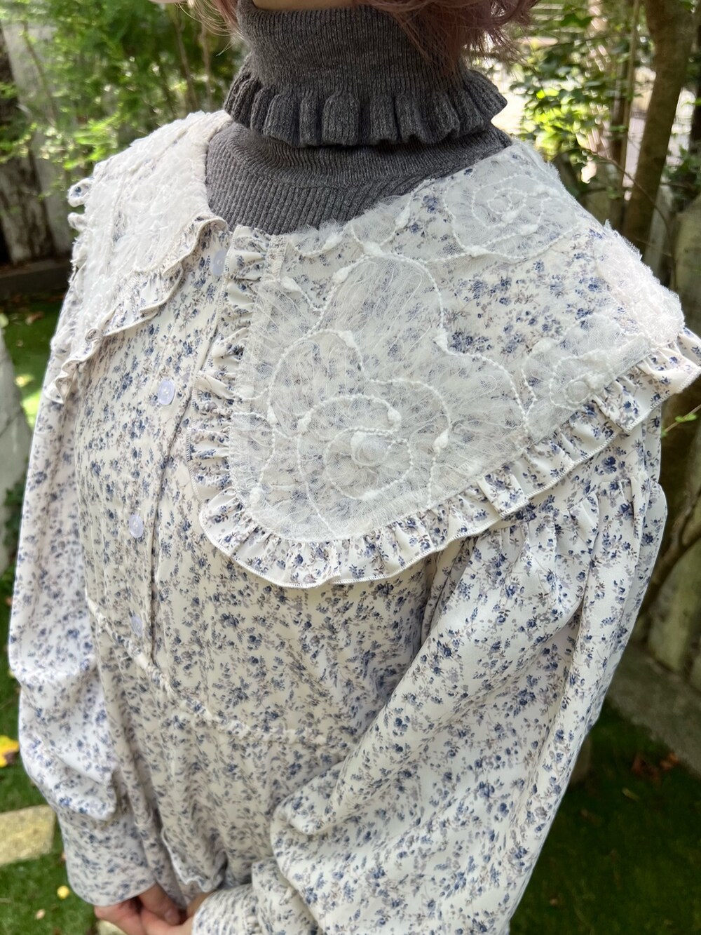 ホワイト系のワンピース、グレー系のニット/セーター、ブラック系のスニーカーを着用したレディースの秋コーディネートの8枚目の写真