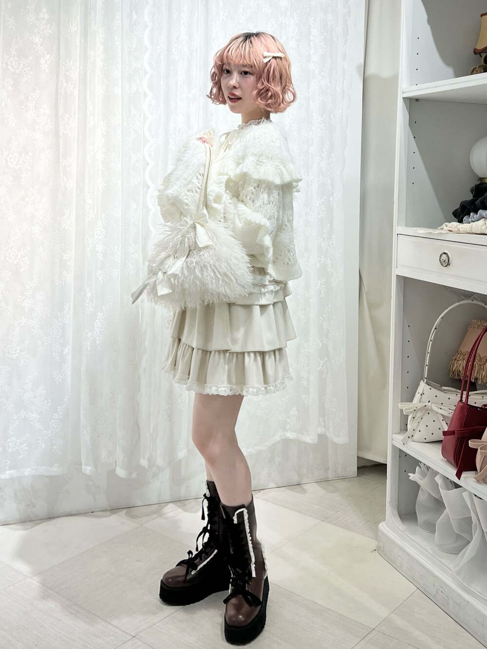 ホワイト系のボストンバッグ、ブラウン系のブーツ、ホワイト系のスカートを着用したレディースの夏コーディネートの4枚目の写真