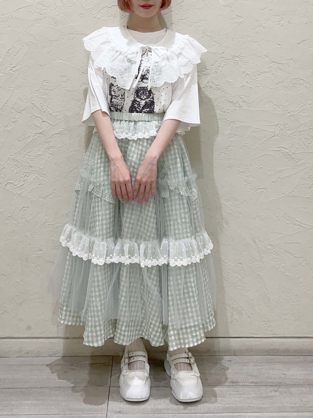 グリーン系のスカート、グリーン系のスカート、ホワイト系のTシャツ/カットソーを着用したレディースの夏コーディネートの2枚目の写真