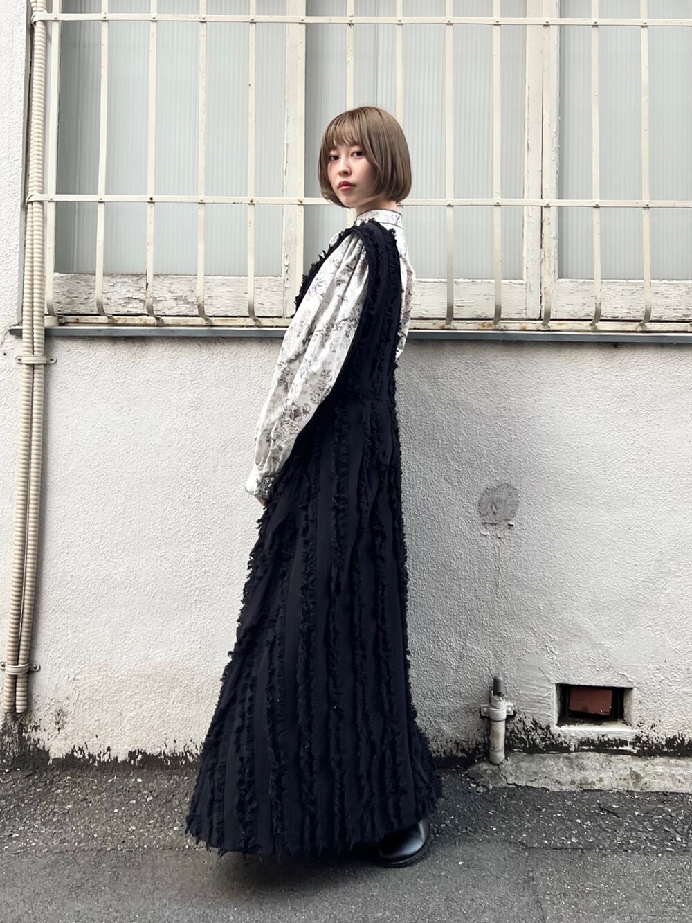 グレー系のシャツ/ブラウス、ブラック系のワンピース、ブラック系のブーツを着用したレディースの秋コーディネートの2枚目の写真