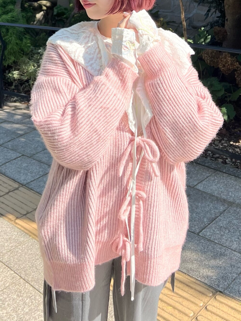ホワイト系のTシャツ/カットソー、グレー系のスラックス、ピンク系のカーディガン/ボレロを着用したレディースの秋コーディネートの5枚目の写真