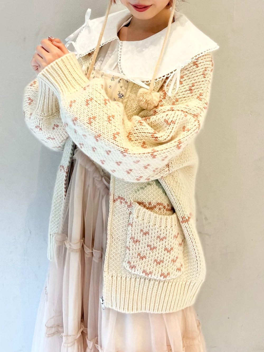 ピンク系のカーディガン/ボレロ、ホワイト系のシャツ/ブラウス、ピンク系のワンピースを着用したレディースの冬コーディネートの8枚目の写真