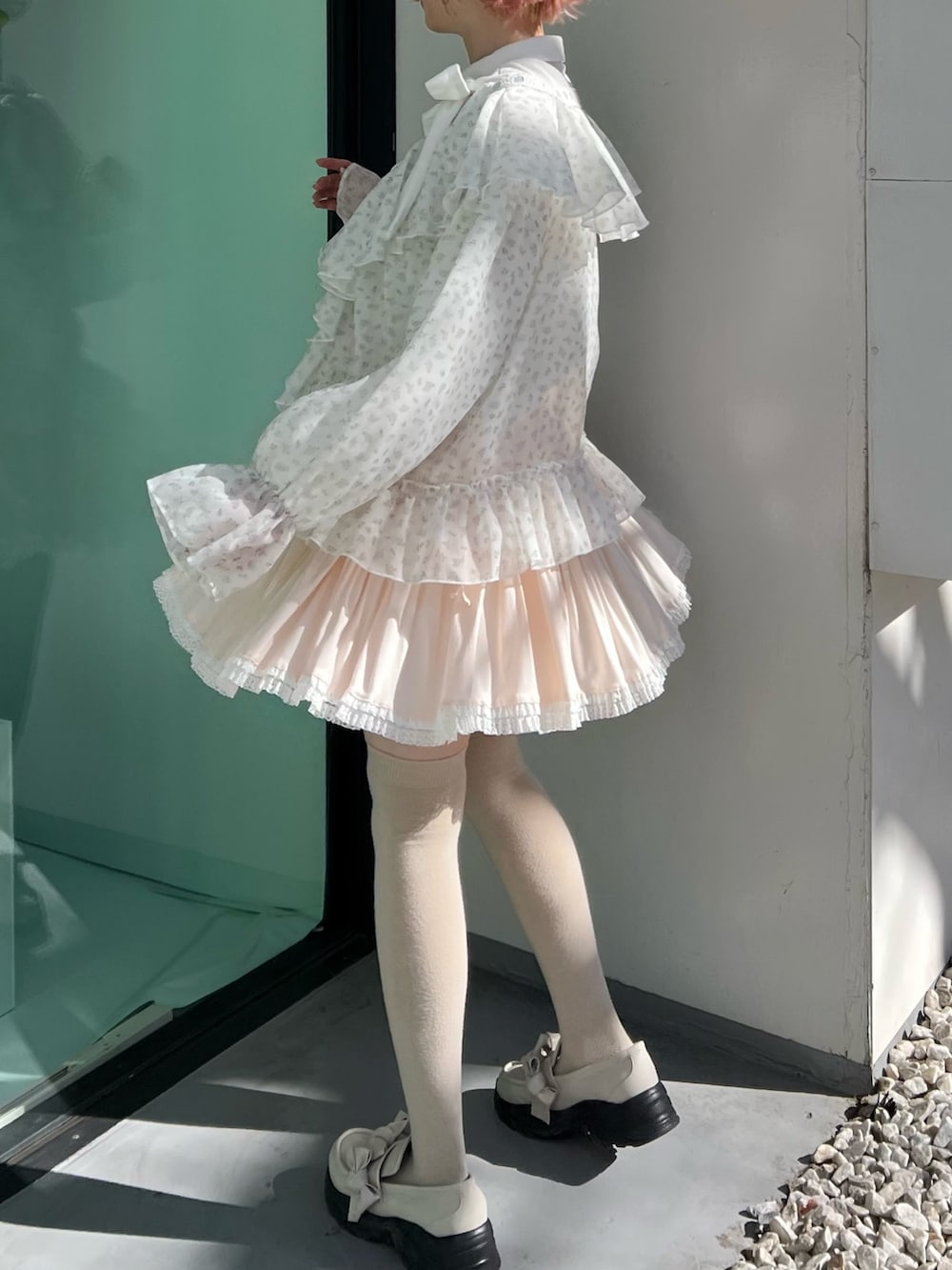 ブルー系のカーディガン/ボレロ、ピンク系のスカート、ホワイト系のスニーカーを着用したレディースの冬コーディネートの3枚目の写真