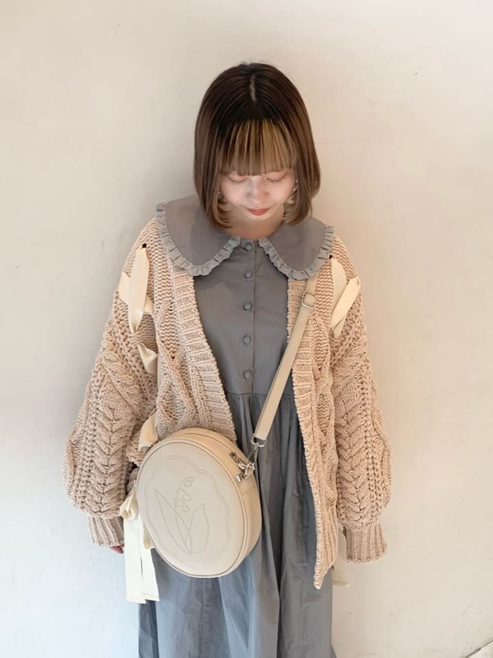 ベージュ系のカーディガン/ボレロ、ホワイト系のスニーカー、ホワイト系のショルダーバッグを着用したレディースの冬コーディネートの7枚目の写真