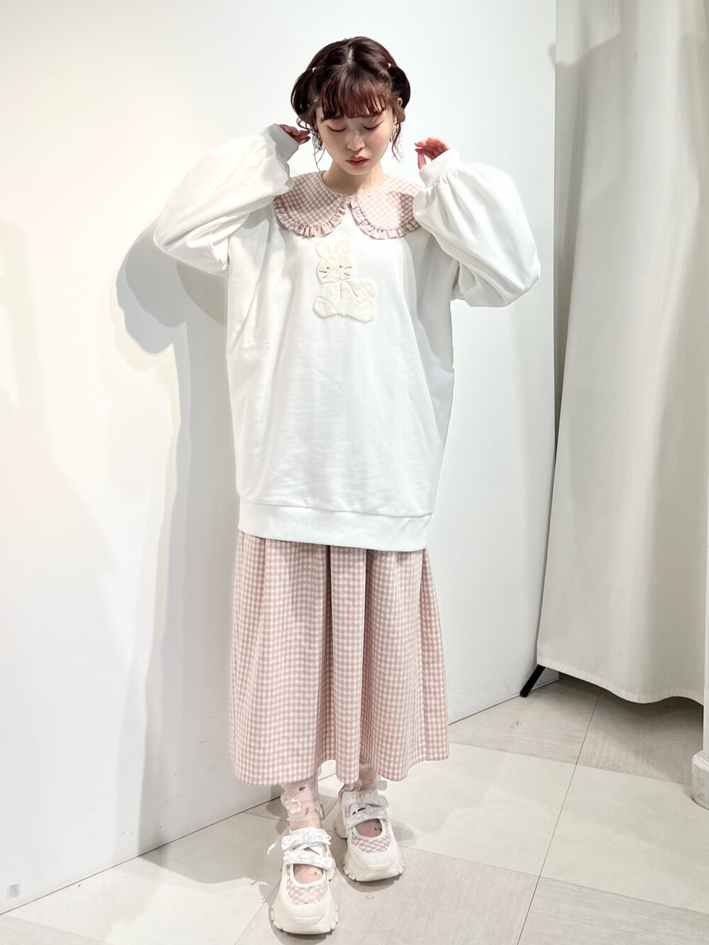 ホワイト系のショルダーバッグ、ピンク系のワンピース、ホワイト系のスウェットを着用したレディースの冬コーディネートの4枚目の写真