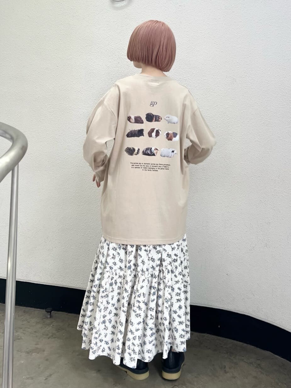 ホワイト系のスカート、ブラック系のパンプス、ベージュ系のTシャツ/カットソーを着用したレディースの夏コーディネートの2枚目の写真