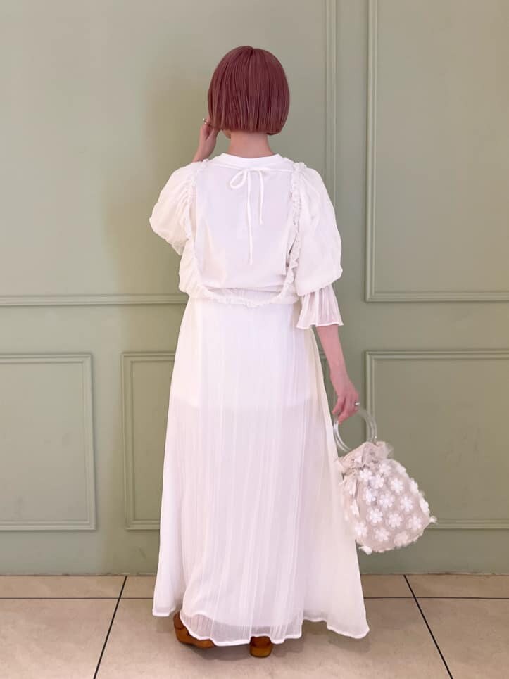 ホワイト系のハンドバッグ、ホワイト系のワンピース、ブラウン系のサンダルを着用したレディースの夏コーディネートの6枚目の写真