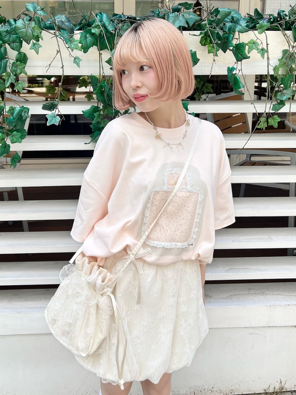 ピンク系のTシャツ/カットソー、ブラウン系のサンダル、ホワイト系のショルダーバッグを着用したレディースの夏コーディネートの3枚目の写真