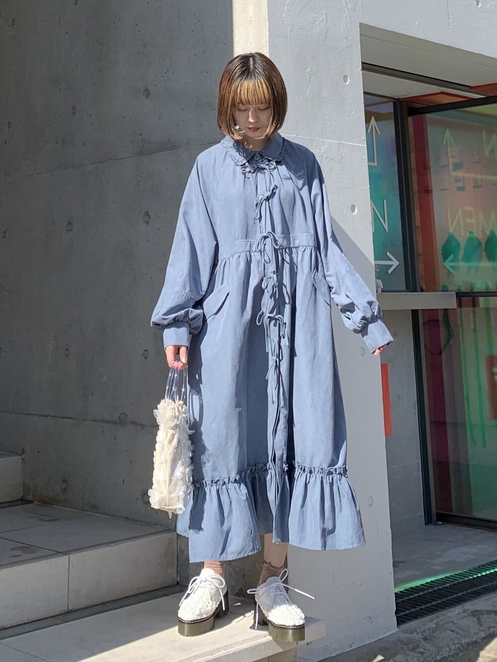 ブルー系のワンピース、ホワイト系のその他シューズ、ホワイト系のハンドバッグを着用したレディースの冬コーディネートの2枚目の写真