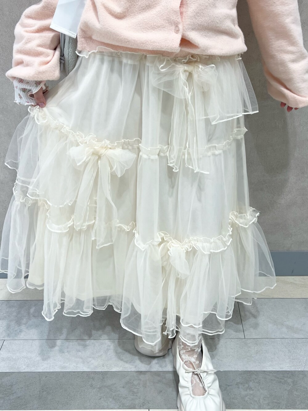 ピンク系のTシャツ/カットソー、ホワイト系のスカート、ホワイト系のスニーカーを着用したレディースの秋コーディネートの10枚目の写真