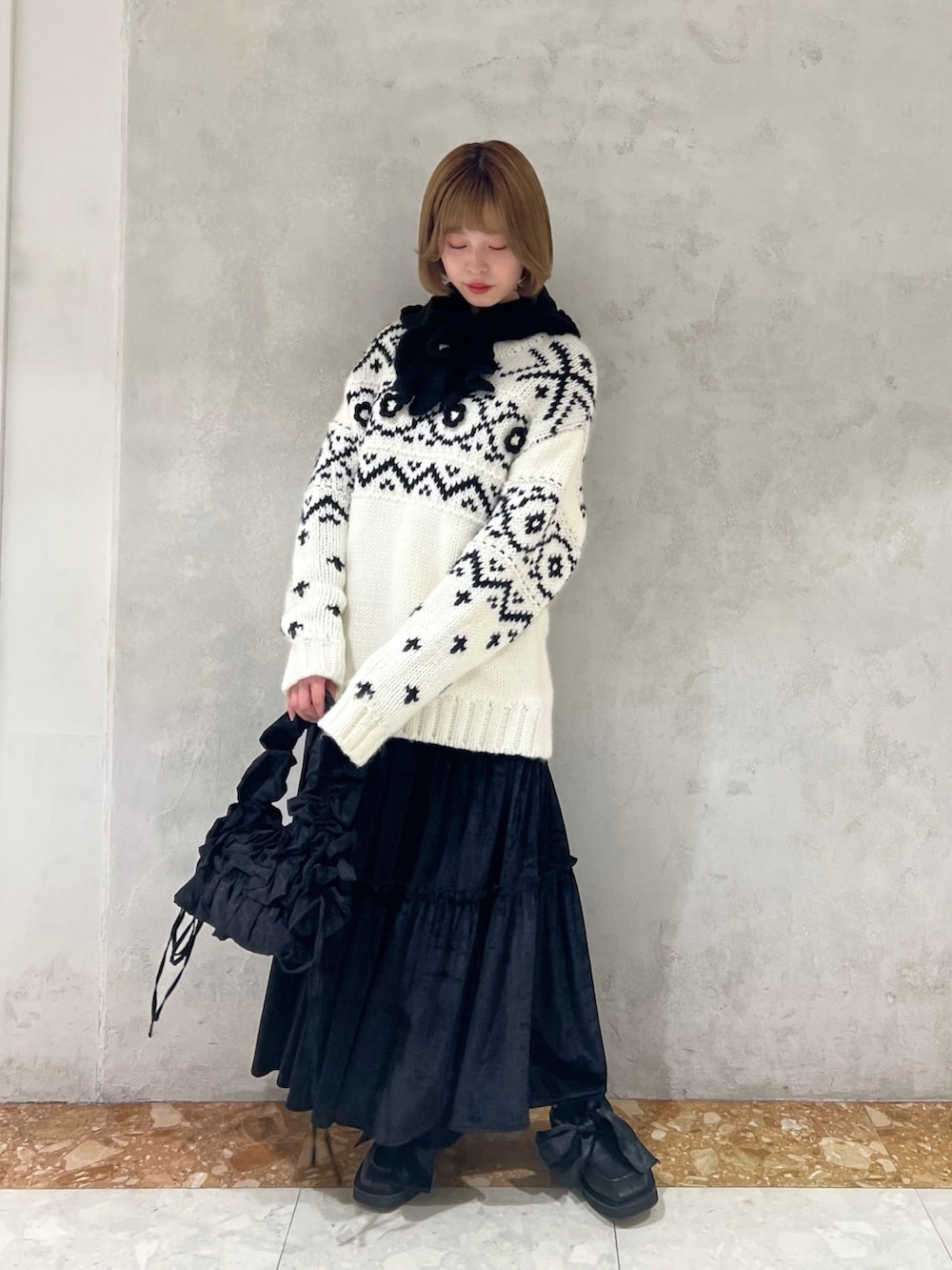 ホワイト系のニット/セーター、ブラック系のショルダーバッグ、ブラック系のモカシン/デッキシューズを着用したレディースの冬コーディネートの2枚目の写真