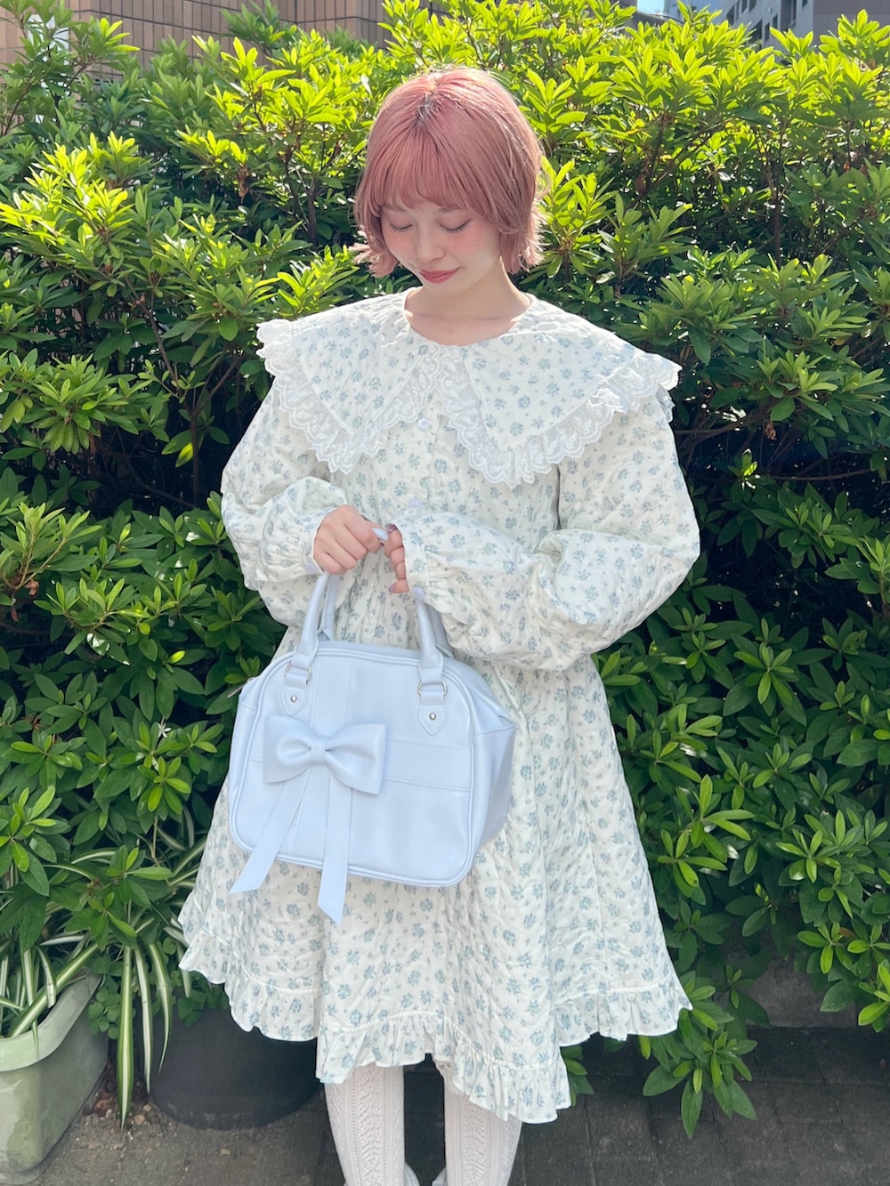 ホワイト系のワンピース、ブルー系のハンドバッグ、ブルー系のブーツを着用したレディースの夏コーディネートの6枚目の写真