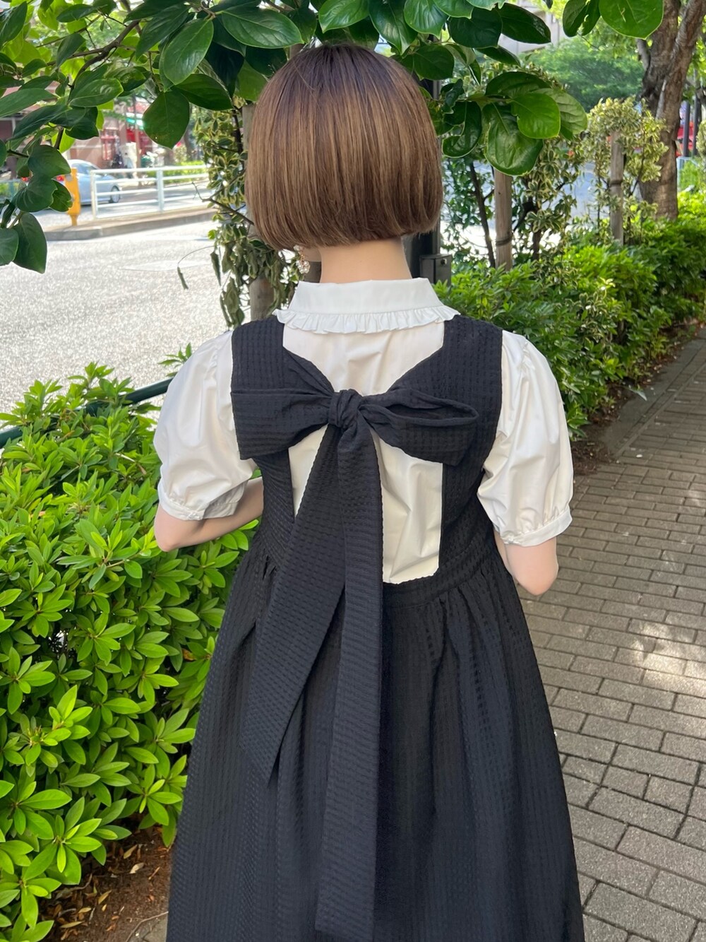 ブラック系のハンドバッグ、ブラック系のワンピース、ブラック系のサンダルを着用したレディースの春コーディネートの4枚目の写真