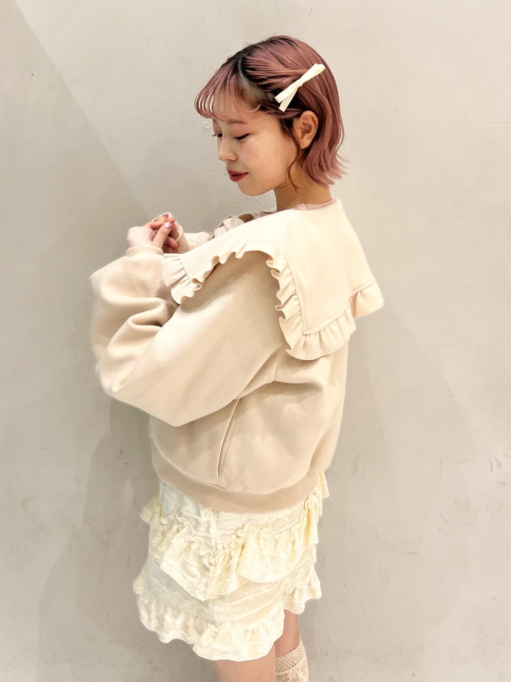 ホワイト系のブルゾン、ピンク系のショルダーバッグ、ホワイト系のスカートを着用したレディースの冬コーディネートの3枚目の写真