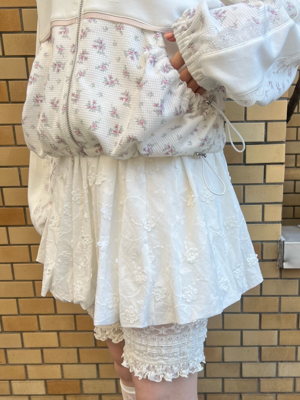 ピンク系のジャージ、ホワイト系のスカート、ホワイト系のスニーカーを着用したレディースの冬コーディネートの9枚目の写真