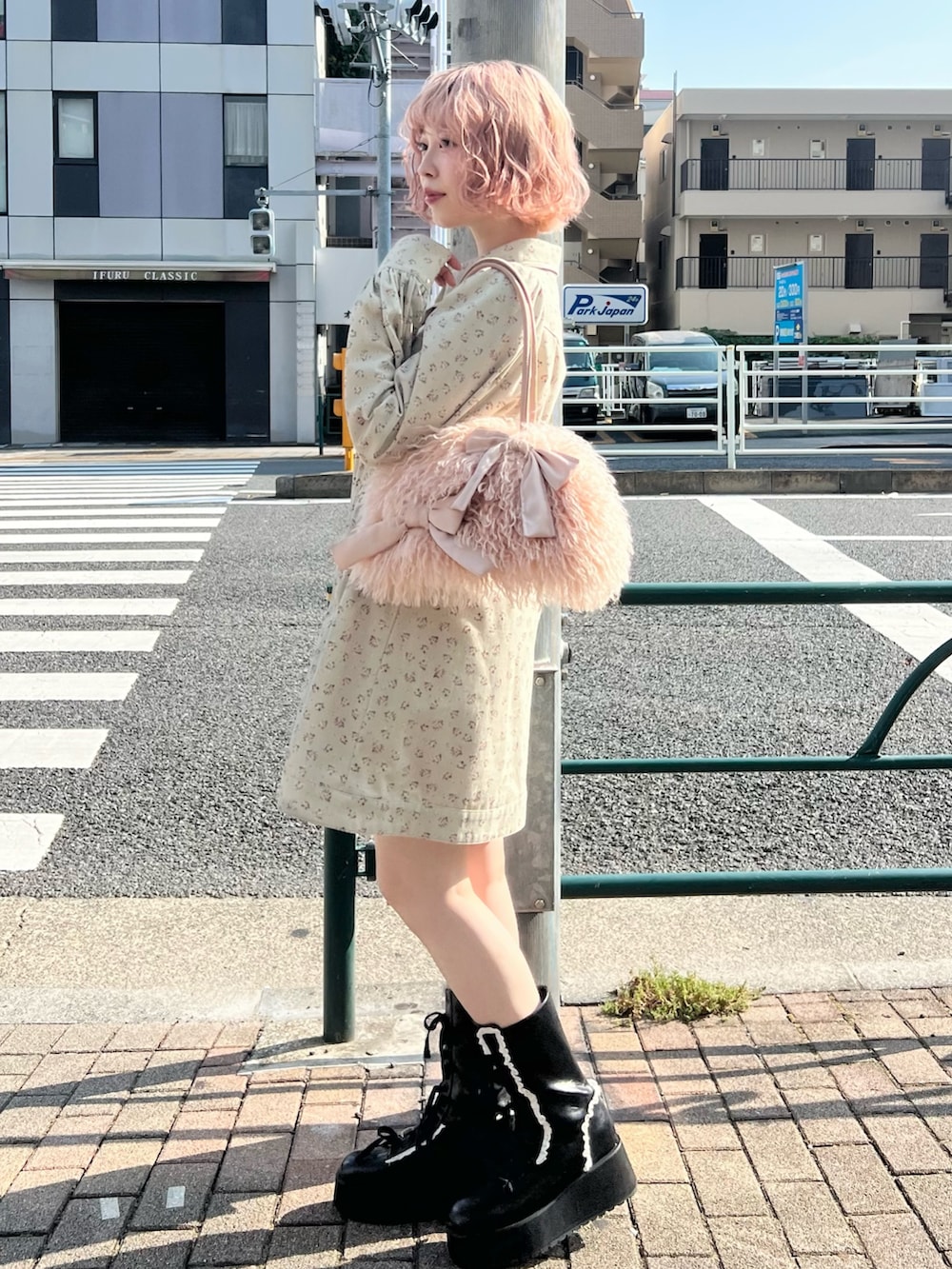 グリーン系のワンピース、ブラック系のブーツ、ピンク系のボストンバッグを着用したレディースの夏コーディネートの3枚目の写真